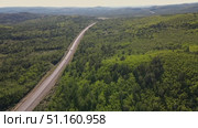 Scenic highway stretches through lush green forest in remote landscape. Стоковое видео, видеограф Гурьянов Андрей / Фотобанк Лори