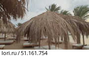Beautiful tropical sunset scenery, two sun beds, loungers, umbrella under palm tree. White sand, sea view with horizon, colorful twilight sky, calmness and relaxation. Inspirational beach resort hotel. Стоковое видео, видеограф Zita Khasanova / Фотобанк Лори