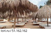 Tropical beach resort scene at sunrise with beach chairs and umbrellas Beautiful panoramic beach. Chairs on the sandy beach near the sea. Summer holiday and vacation concept for tourism. Inspirational tropical landscape. Tranquil scenery, relaxing beach, tropical landscape design. Стоковое фото, фотограф Zita Khasanova / Фотобанк Лори