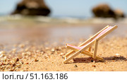 Mini sun lounger on the beach by the sea. The concept of recreation and holidays at the sea. Стоковое фото, фотограф Igor Skripachev / Фотобанк Лори