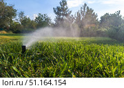 Automatic garden irrigation system watering lawn. Automatic equipment for irrigation and maintenance of lawns, gardening. Стоковое фото, фотограф Владислав Тригуб / Фотобанк Лори
