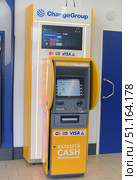 A modern ChangeGroup ATM designed for withdrawing cash from international bank cards. The device is designed in a bright yellow and gray design with inscriptions in English and Finnish. The ChangeGroup logo is located on the top panel, as well as a built-in screen where popular Internet services are visible (YouTube, Netflix, AccuWeather, etc.). The logos of the MasterCard, Visa, and Maestro payment systems stand out on the body. The ATM screen displays a welcome message asking you to insert a card. At the bottom there is a slot for cash withdrawal and receipt acceptance.The photo is suitable for topics related to banks, finance, international transfers, the use of plastic cards abroad, as well as for illustrating tourist infrastructure. (2015 год). Редакционное фото, фотограф Анна Кривицкая / Фотобанк Лори