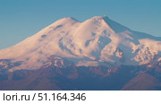 4k, A panoramic view of the snow-capped peaks of Mount Elbrus, the highest point of the European continent, against a clear blue sky, at daytime, Stavropol Krai, Russia. Стоковое видео, видеограф Сергей Богомяко / Фотобанк Лори