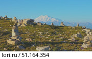 4k, panoramic view of the Bolshoy Bermamyt plateau with stone turrets built on a grassy slope, with the snow-capped peaks of Mount Elbrus in the background, at early morning, Stavropol Krai, Russia. Стоковое видео, видеограф Сергей Богомяко / Фотобанк Лори