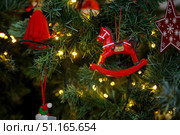 Toy red horse hanging on a green branch of a Christmas tree. Стоковое фото, фотограф Aleksandra Selivanova / Фотобанк Лори