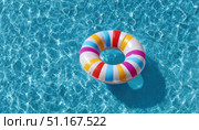 Colorful inflatable ring drifting across sparkling blue pool water, representing summer leisure and carefree poolside enjoyment. Стоковое AI-изображение, AI-художник Юрий Поздников / Фотобанк Лори