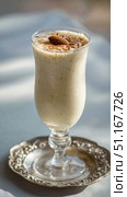 Chilled badam doodh presenting creamy almond milk in delicate glass, topped with golden saffron threads and single almond, representing traditional indian refreshing beverage. Стоковое AI-изображение, AI-художник Юрий Поздников / Фотобанк Лори