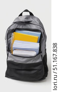 Student gray black backpack holding academic supplies notebooks, textbook, folders, pens resting against clean white surface, ready for educational journey. Стоковое AI-видео, аниматор Юрий Поздников / Фотобанк Лори