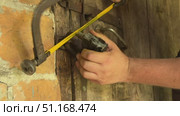 Man cutting padlock with hacksaw. Vintage wooden door in brick wall. He knocks the lock off with a hammer. Стоковое видео, видеограф Vadzim Yakubovich / Фотобанк Лори
