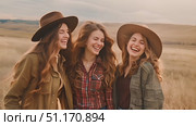Three friends laugh heartily together in a beautiful, sunlit field in the countryside. Стоковое AI-видео, аниматор Данила Большаков / Фотобанк Лори