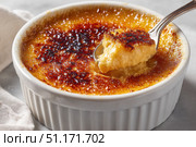 Creme brulee. dessert with caramel crust. Elegant Gourmet Dessert with Caramelized Sugar Crust. French vanilla cream. Eating Creme Brulee with Spoon. Cracking caramel. Delicious Sweet. Catalan cream. Стоковое AI-изображение, AI-художник Марина Демидюк / Фотобанк Лори