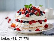 Gourmet pavlova cake with fresh berry topping. Delicious Pavlova dessert on white gray blurred table background. Summer treat. Delight strawberries, blueberries, blackberries, raspberry, mint leaves. Стоковое AI-изображение, AI-художник Марина Демидюк / Фотобанк Лори