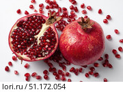 Pomegranates. Pomegranate isolated on a white transparent background. Juicy garnet fruit whole and its half with leaves and details. Piece of pomegranate with seeds. Side view. Freshness and abundance. Стоковое AI-изображение, AI-художник Марина Демидюк / Фотобанк Лори