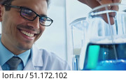 A smiling scientist mixes a blue liquid while working in a bright laboratory setting. Стоковое AI-видео, аниматор Данила Большаков / Фотобанк Лори