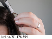 Young woman holding hair while hairstylist applies solution to remove capsule extensions in beauty salon. Стоковое фото, фотограф Svetlana Golovco / Фотобанк Лори