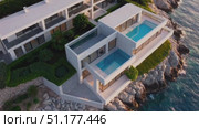 Smooth slow-motion aerial glides over layered terraces and a rooftop pool of a sleek seaside residence — elegant 4K 16:9 architecture clip for property promos. Стоковое AI-видео, аниматор Владислав Войтов / Фотобанк Лори