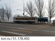 Движение троллейбуса  Тролза - 5275 по заснеженной улице, остановка ул.Кропоткина . Волгоград, Россия (2022 год). Редакционное фото, фотограф Андрей Цыганков / Фотобанк Лори