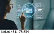 A professional woman engages with augmented reality graphics to analyze data insights in a contemporary office environment. Стоковое AI-видео, аниматор Данила Большаков / Фотобанк Лори