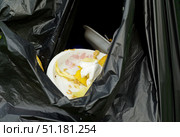 plastic plates with food waste in a gray plastic bag. Стоковое фото, фотограф Андрей Митин / Фотобанк Лори