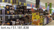In a supermarket and shows shelves of products decorated in brightly coloured advertising packaging. In the foreground are boxes labelled Grilli Maistari, a range of sauces, seasonings and grilling products. Next to them are yellow boxes of Taffel snacks and chips. In the background are products from other brands, including Lay’s Sensations. The price tags on the top list the prices of various sauces, spices and products, starting from €1.49. The atmosphere of the store is typical of large supermarkets: bright lighting, saturated colours of the packaging and a wide variety of products. (2015 год). Редакционное фото, фотограф Анна Кривицкая / Фотобанк Лори