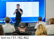 Audience listens to speaker at seminar with screen in background. Стоковое фото, фотограф Антон Гвоздиков / Фотобанк Лори