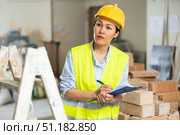 Female builder fills out documentation during repair work. Стоковое фото, фотограф Яков Филимонов / Фотобанк Лори