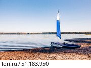 Kayak canoe with sail is moored on shore of Lake pond Ladoga in Karelia, Russia. Стоковое фото, фотограф Spirit River / Фотобанк Лори
