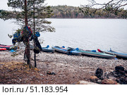 Kayak lying on shore calm lake on cloudy day, forest trees and water background. Стоковое фото, фотограф Spirit River / Фотобанк Лори