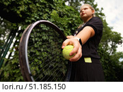 Teenage Girl Perfects Her Tennis Skills on a Vibrant Outdoor Court Surrounded by Lush Greenery. Стоковое фото, фотограф Aleksandr Golubev / Фотобанк Лори