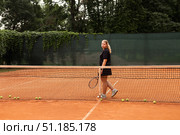 Teenage Girl Practices Her Tennis Skills on a Sunny Outdoor Court Surrounded by Nature. Стоковое фото, фотограф Aleksandr Golubev / Фотобанк Лори