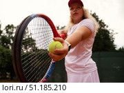Teenage Girl Focuses Intensely While Training on the Tennis Court During a Sunny Day. Стоковое фото, фотограф Aleksandr Golubev / Фотобанк Лори