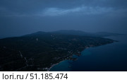 Dark coastline emerging from the Aegean sea at dusk in Sithonia, Greece. Стоковое фото, фотограф Данил Руденко / Фотобанк Лори