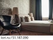 Inviting Bedroom Retreat With Stylish Furnishings and Abundant Natural Light. Стоковое фото, фотограф Aleksandr Golubev / Фотобанк Лори