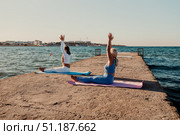 Yoga Women Beach Pose - Two women practice yoga on a pier by the sea. Стоковое фото, фотограф svetograph / Фотобанк Лори
