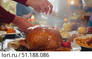 A beautifully roasted turkey sits on the dining table surrounded by delicious side dishes and vibrant decorations during a family feast. Стоковое AI-видео, аниматор Данила Большаков / Фотобанк Лори