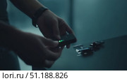 A man clad in dark clothing walks into a shadowy, technologically advanced environment, hinting at an intense mission unfolding. Стоковое AI-видео, аниматор Данила Большаков / Фотобанк Лори