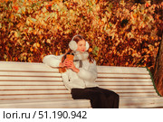 Enjoying Autumn Day in the Park, a Teenage Girl Captures the Beauty of Nature With Her Smartphone. Стоковое фото, фотограф Aleksandr Golubev / Фотобанк Лори