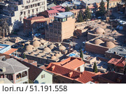 Tbilisi, Georgia - January 04, 2023: Old City Center. View of the ancient baths from the Narikala fortress. Редакционное фото, фотограф Наталия Кирсанова / Фотобанк Лори
