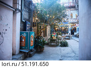 Tbilisi, Georgia - 04 January, 2023: Shota Rustaveli Avenue. Cafe in the gateway with Christmas decorations. Редакционное фото, фотограф Наталия Кирсанова / Фотобанк Лори