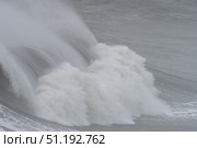 Powerful ocean waves surging against rocky shoreline, displaying dramatic natural force and maritime landscape dynamism. Стоковое фото, фотограф Данил Руденко / Фотобанк Лори