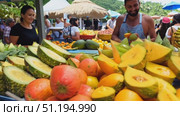 A lively local market showcases vibrant tropical fruits and welcoming vendors engaging with visitors on a sunny day. Стоковое AI-видео, аниматор Данила Большаков / Фотобанк Лори