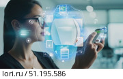 A young woman interacts with a smartphone while engaging with a holographic display in a sleek, contemporary office setting. Стоковое AI-видео, аниматор Данила Большаков / Фотобанк Лори