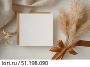 Blank greeting card, invitation mockup. Dry grass, pampas plant on beige table background. Flat lay, top view. Copyspace. Paper cards, mock up. Modern Minimal business brand template. Soft shadow. A6. Стоковое AI-изображение, AI-художник Марина Демидюк / Фотобанк Лори