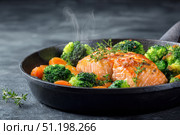 Steamed fish with with broccoli, carrot hot black pan. Baked salmon gray background. Paleo, keto, lshf, or dash diet. Fish and vegetables. Oven dish, gluten free, clean eating, balanced healthy food. Стоковое AI-изображение, AI-художник Марина Демидюк / Фотобанк Лори