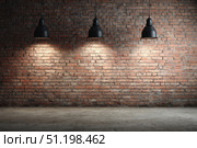 Modern black pendant lights with vintage light bulb hanging among bricks wall. Hanging ceiling light in a white shared office space. Decorative geometric metal lamp. Suspended chandelier loft style. Стоковое фото, фотограф Марина Демидюк / Фотобанк Лори