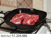 Two fresh raw meat of beef steak Prime Black Angus Chuck roll steak grilled in pan on gas stove. Стоковое фото, фотограф Ирина Буракова / Фотобанк Лори