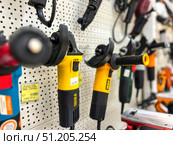 A row of power tools are hanging on a wall, including a green and black drill. Russia. Moscow. 24.08.25. Редакционное фото, фотограф Ярославский Максим / Фотобанк Лори