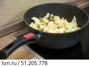 Fresh cauliflower florets and green beans are being cooked in a non-stick frying pan on an electric stove for a healthy dish. Стоковое фото, фотограф Андрей Журавлев / Фотобанк Лори