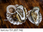 Морской еж, устрицы, гребешок с лимоном на деревянном фоне. Стоковое фото, фотограф Алексей Линник / Фотобанк Лори