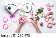 Flower shop: A girl makes a bouquet of roses in a round box. Close-up of hands. Стоковое фото, фотограф Енваев Андрей / Фотобанк Лори